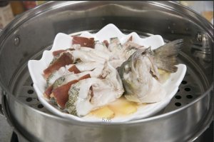 將鱸魚成花狀擺好，將火腿切片放入各縫隙中，放入鍋中隔水蒸12分鐘拿出，撒上蔥花即可。