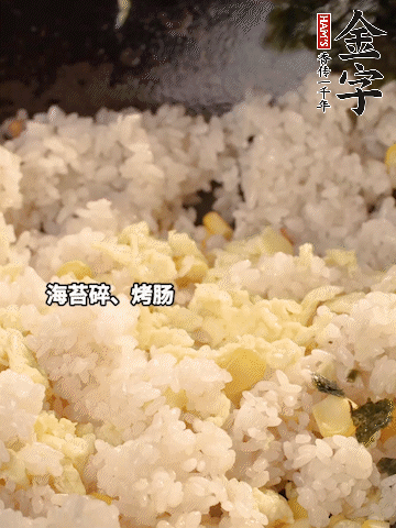 剩米飯下鍋炒散，依次下玉米粒、雞蛋、烤腸、海苔碎翻炒均勻。