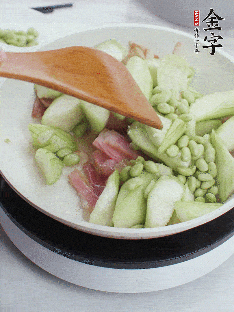 依次下絲瓜、青豆翻炒，炒至絲瓜打蔫縮小。
