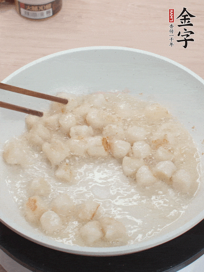 油溫4成熱，鮮貝蘸干淀粉下鍋煎，一面微黃后翻面。