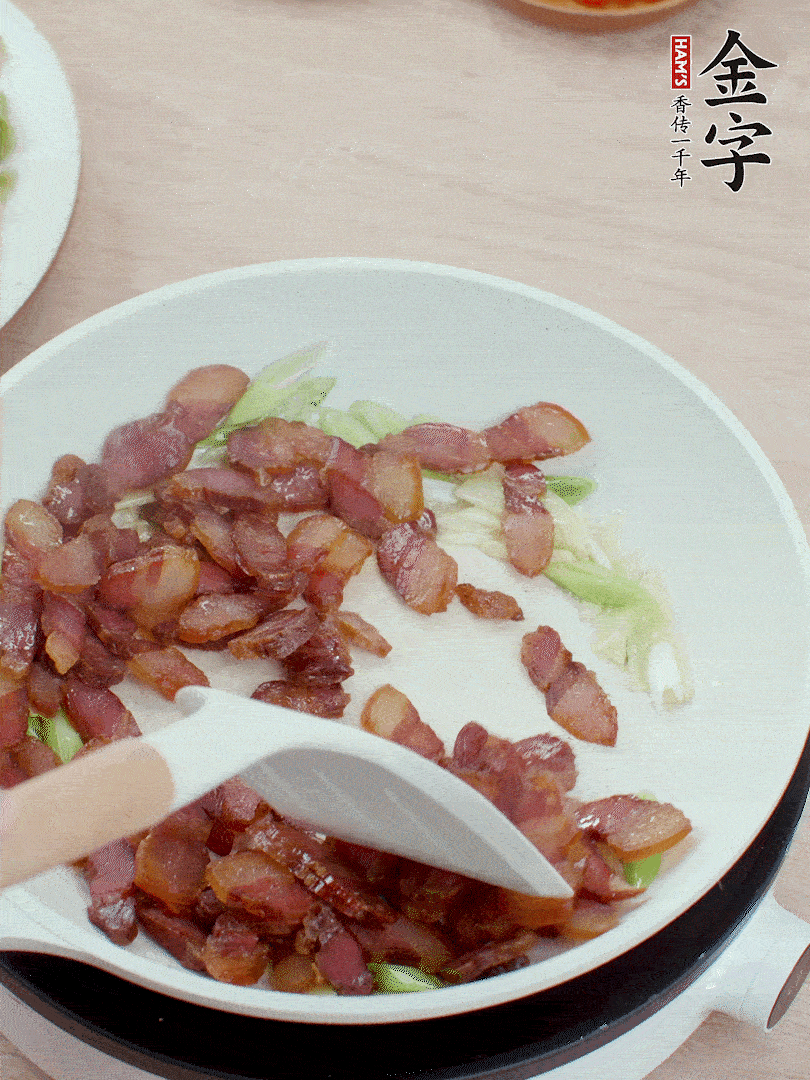 鍋中少許油，姜、蒜白爆香，下臘肉煸出油脂。