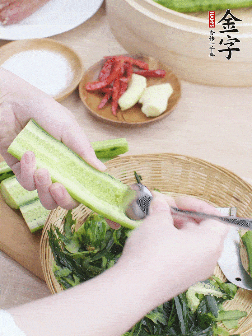 黃瓜削皮，對(duì)半切開，勺子挖去內(nèi)瓤，斜刀切片。青蒜斜刀切段。