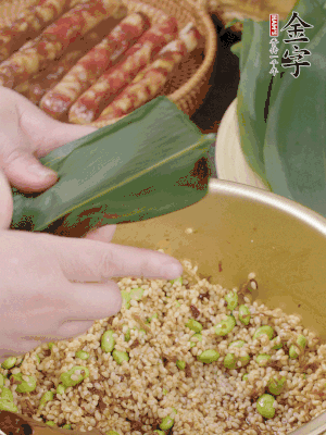 粽葉往下折，完全蓋住，兩側捏緊。
