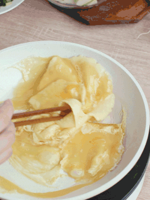 油6成熱時(shí)，下雞蛋液，邊緣凝固時(shí)翻拌成塊狀。