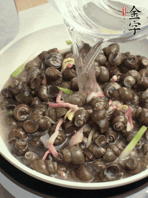 倒處理干凈的螺螄翻炒，加3勺料酒。加清水蓋過螺螄，中火蓋蓋煮5分鐘。