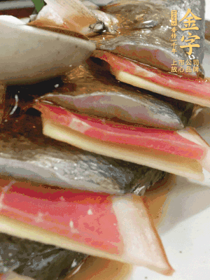 魚肚中塞蔥結(jié)、火腿片，魚身上碼放姜片、火腿片，倒入混合的料汁。