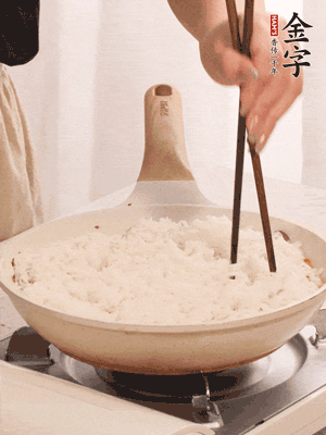 把瀝干水分的米飯均勻鋪在上面，筷子戳幾個(gè)洞，以便透氣，轉(zhuǎn)小火蓋上蓋子燜至水分收干，大概10分鐘。